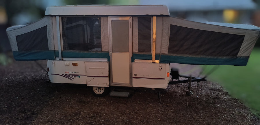 This Fleetwood Coleman pop-up RV rental is set up outdoors, ready for a camping trip. Perfect for an RV adventure.