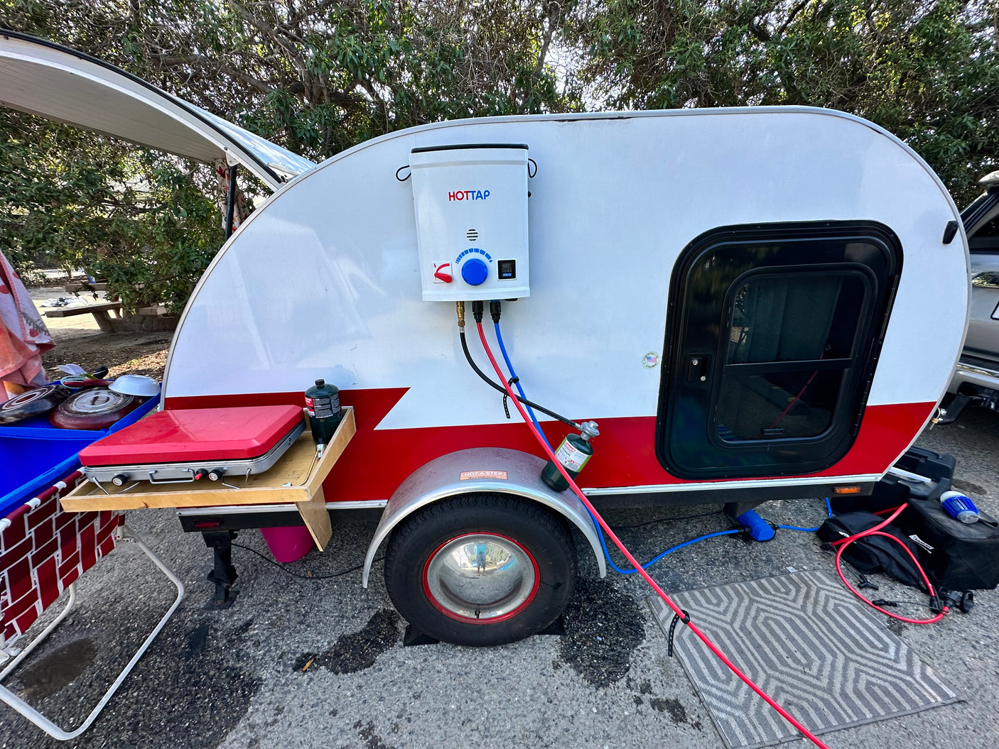 Teardrop camper RV rental with external water heater & outdoor kitchen for camping adventures.