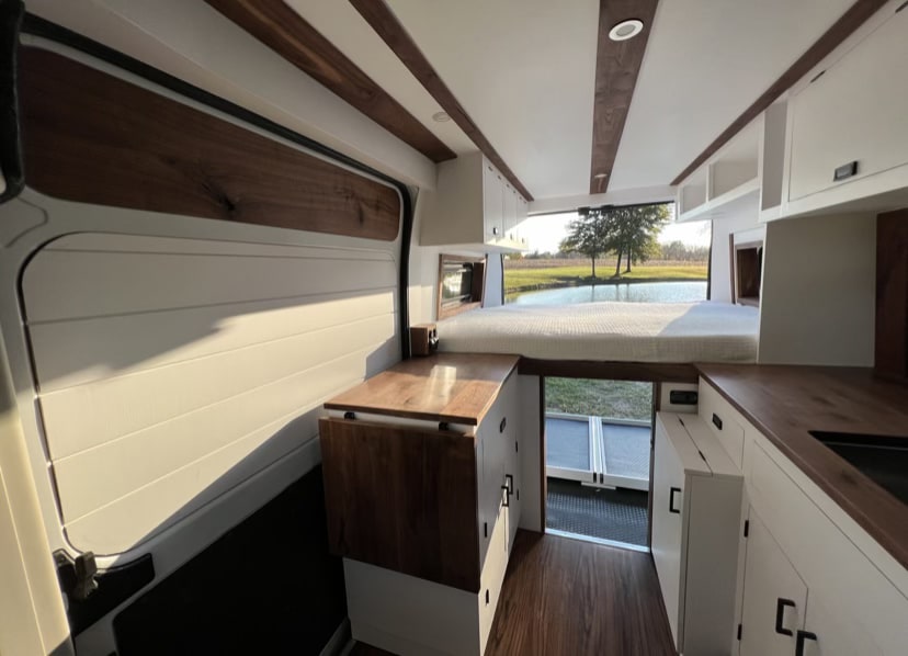 and front seats.|Step inside this clean RV rental camper van. Features include a kitchen — photo 7