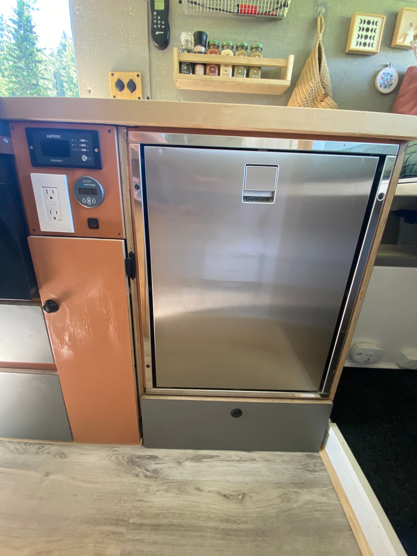 RV rental kitchen: stainless Isotherm refrigerator, Xantrex & Victron controls, spice rack, and power outlet visible.