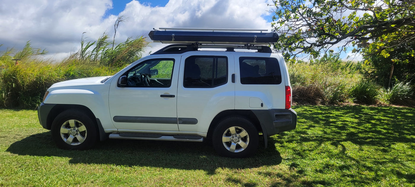 White SUV with a roof tent, parked on grass. An RV rental alternative for your outdoor adventures. — photo 4