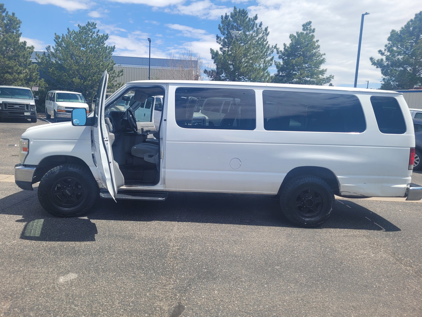 White Ford passenger van with open door, part of an RV rental fleet, ready for your next trip. — photo 12