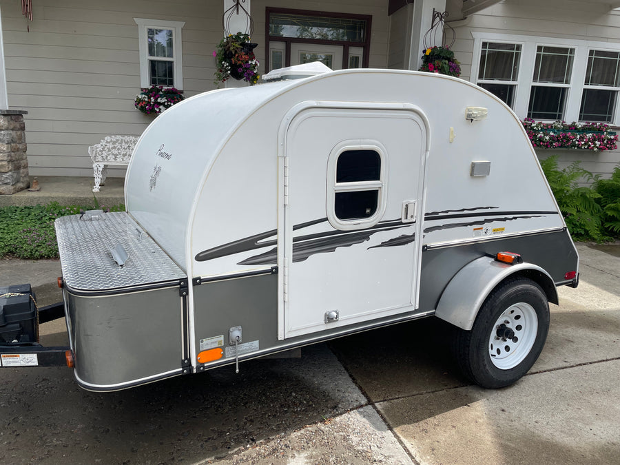 A white and gray teardrop travel trailer