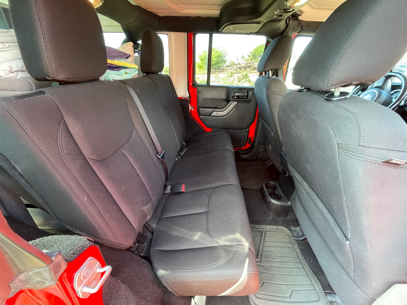 Inside an RV rental adventure vehicle: spacious black back seats, cup holders, and durable floor mats, perfect for travel.