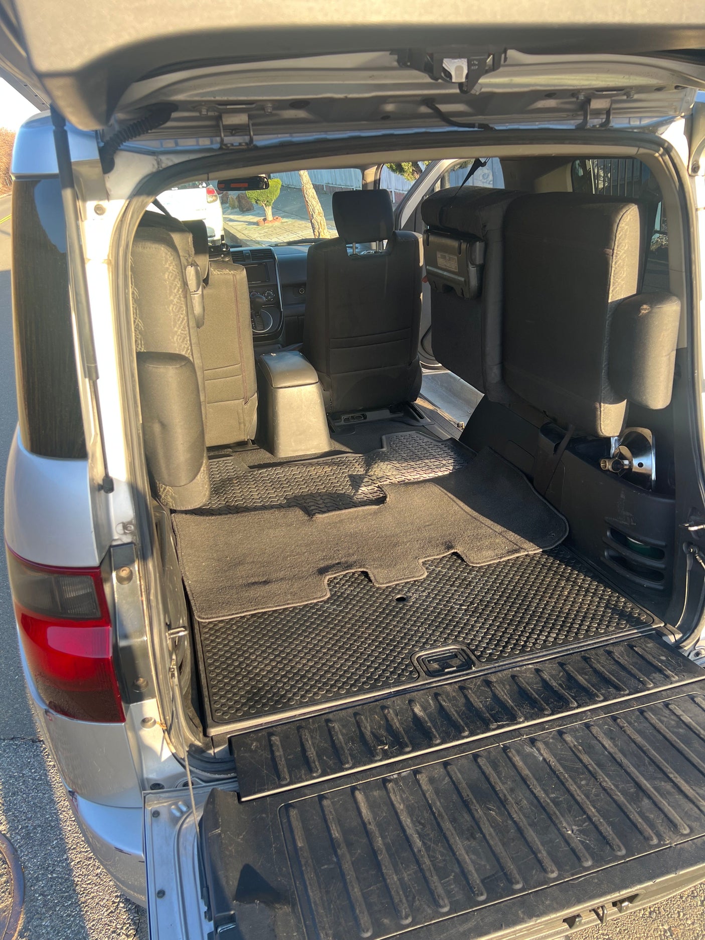 View inside an RV rental's rear cargo area with versatile fold-flat seats and durable floor mats, ready for your adventure.