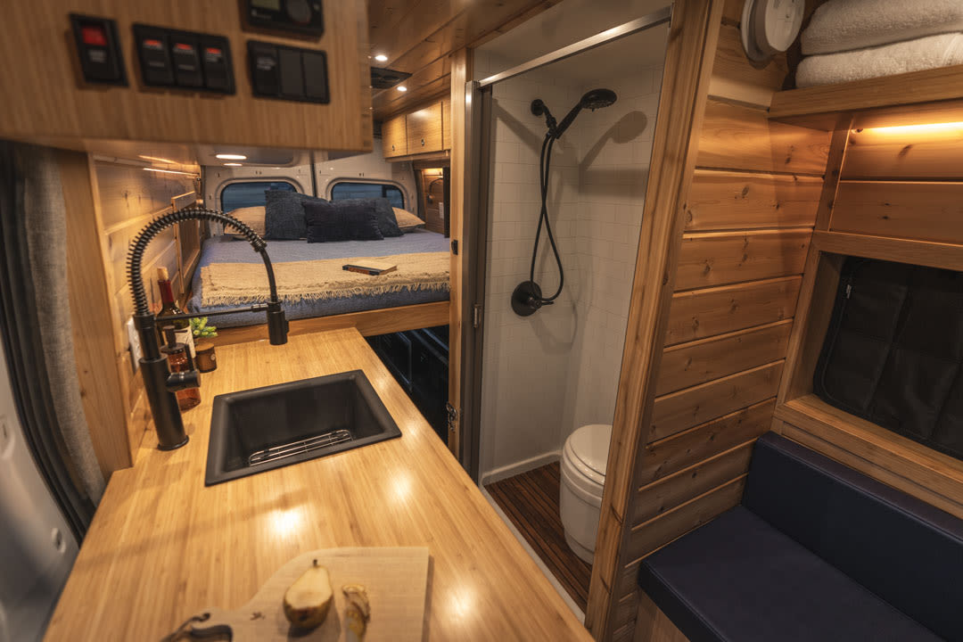 and front cabin.|Open rear doors of this white RV rental camper van reveal a comfortable bed