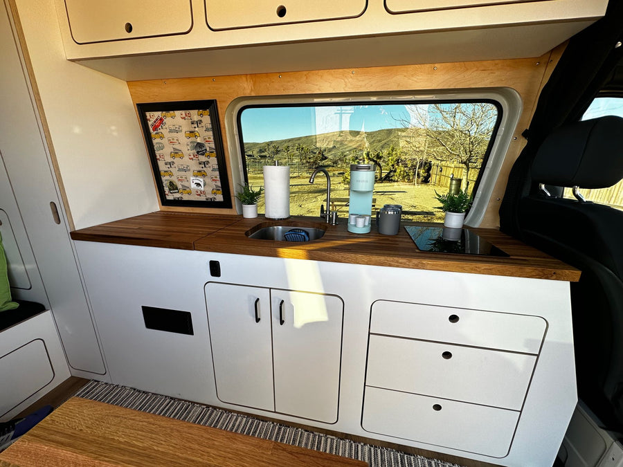 Spacious RV rental interior featuring a full kitchen, scenic window views, and ample storage for comfortable mobile living.