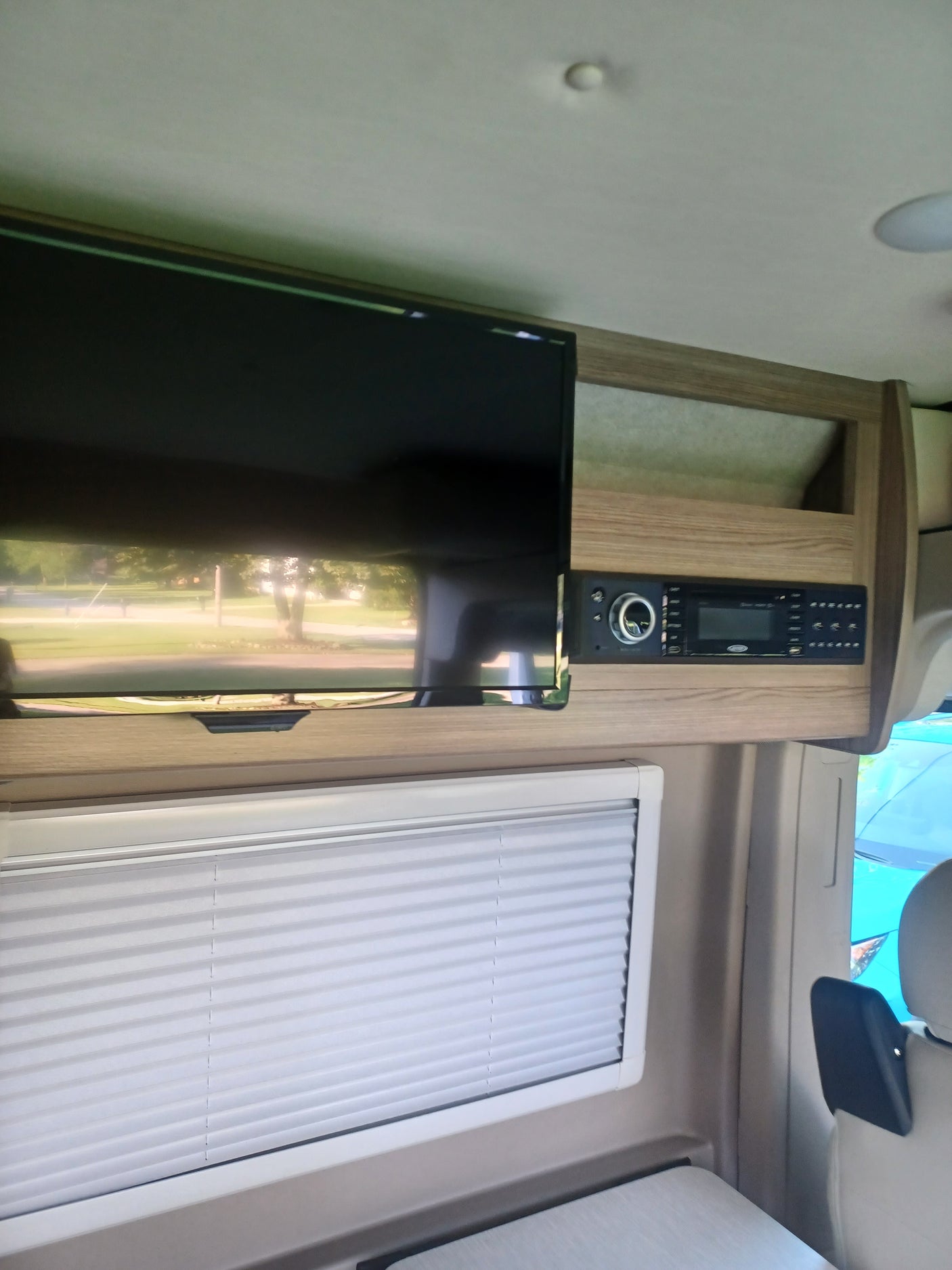 This RV rental features a flat-screen TV, an electronic control panel, and a pleated window blind.