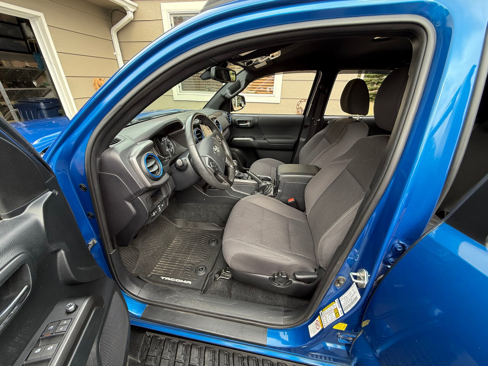 Bright blue truck interior: steering wheel, dashboard, and cloth seats visible. A reliable choice for your RV rental needs.