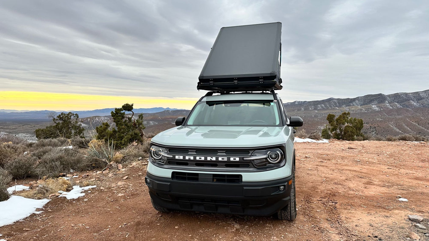 set in snowy mountains at sunset. Consider for your next RV rental adventure.|Adventure-ready Bronco Sport with rooftop tent