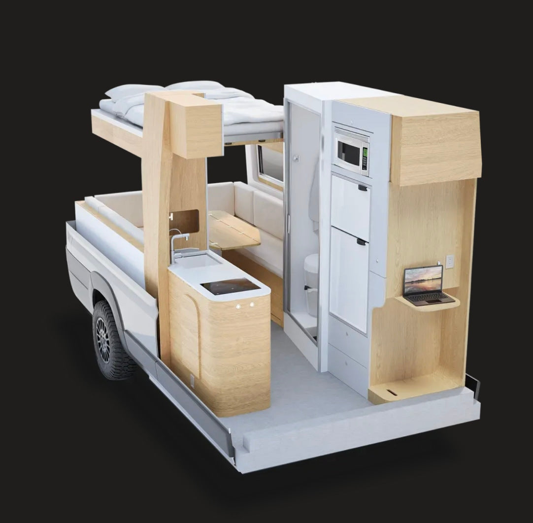 A detailed view of a modular RV rental's interior, showcasing a compact kitchen, bed, bathroom, and laptop workstation.