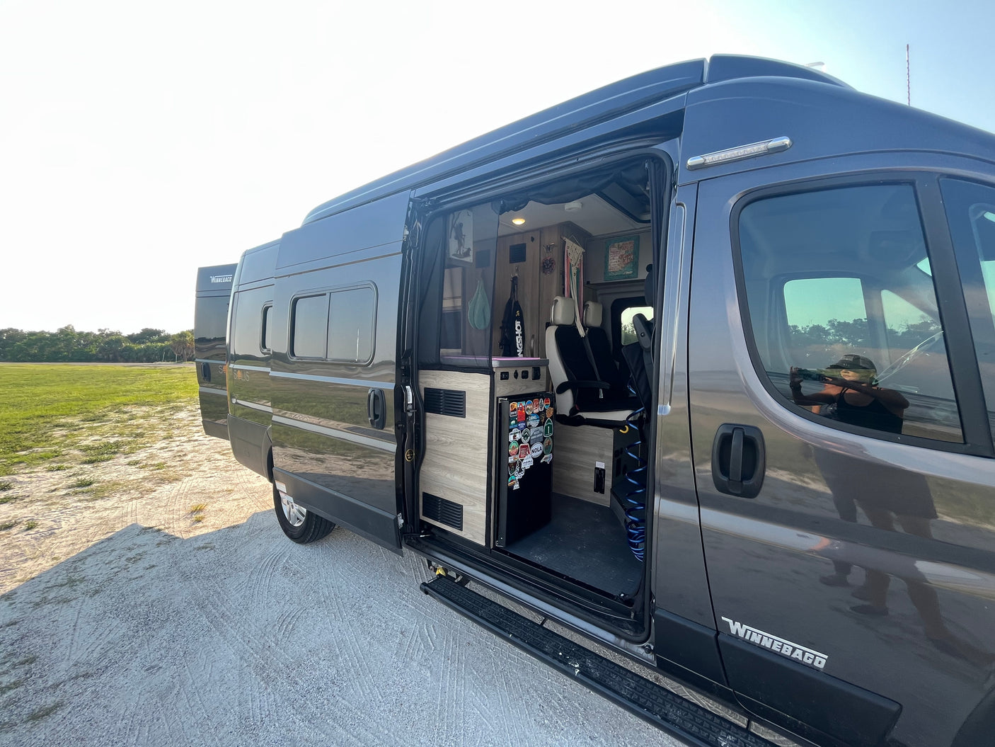 Get ready for your next road trip! Winnebago camper van RV rental with open door displaying its well-equipped interior.