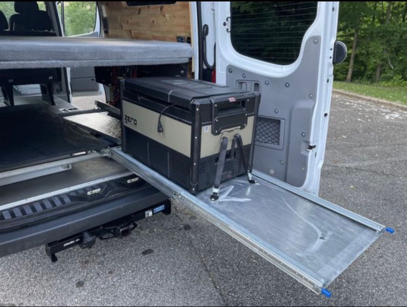 and a TriStar solar charge controller visible.|White van RV rental with open side door reveals passenger seating & spacious interior for travel.|Explore the interior of this RV rental