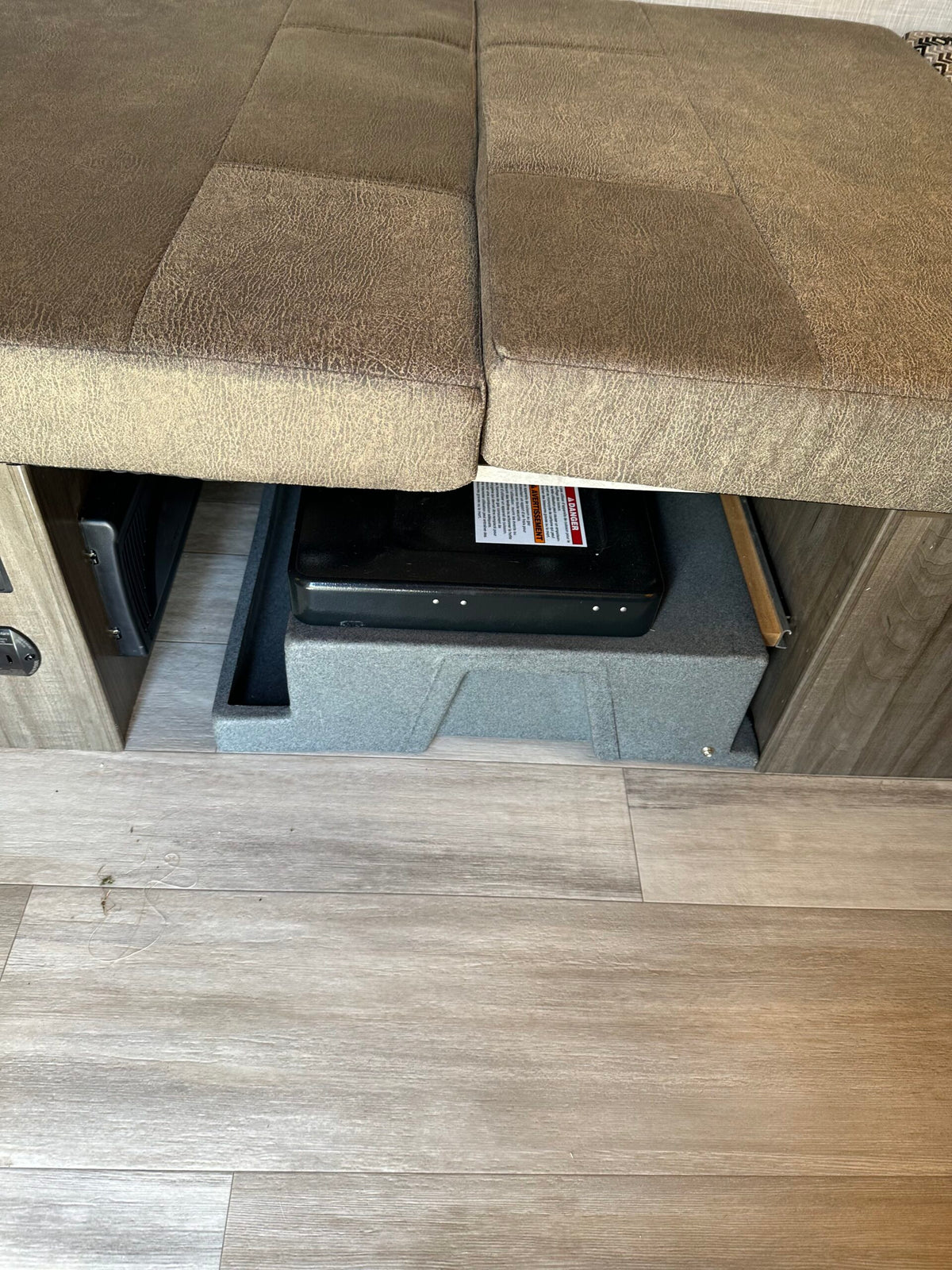 RV rental: Under-bench storage featuring a portable stove, an RV heating/cooling vent, and durable wood-look flooring. — photo 5