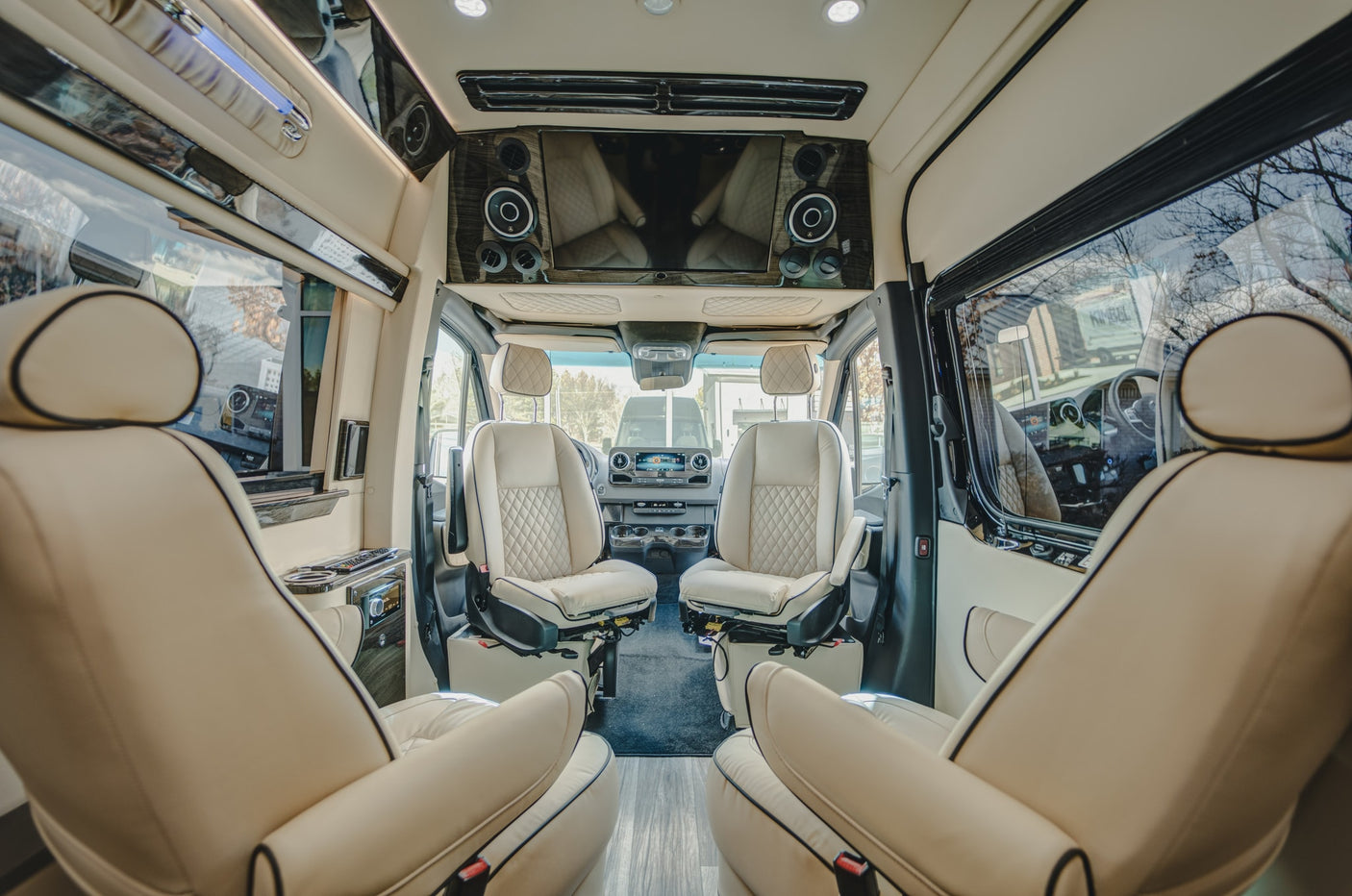 large windows & TV for luxury travel.|Black luxury Mercedes-Benz Sprinter van RV rental