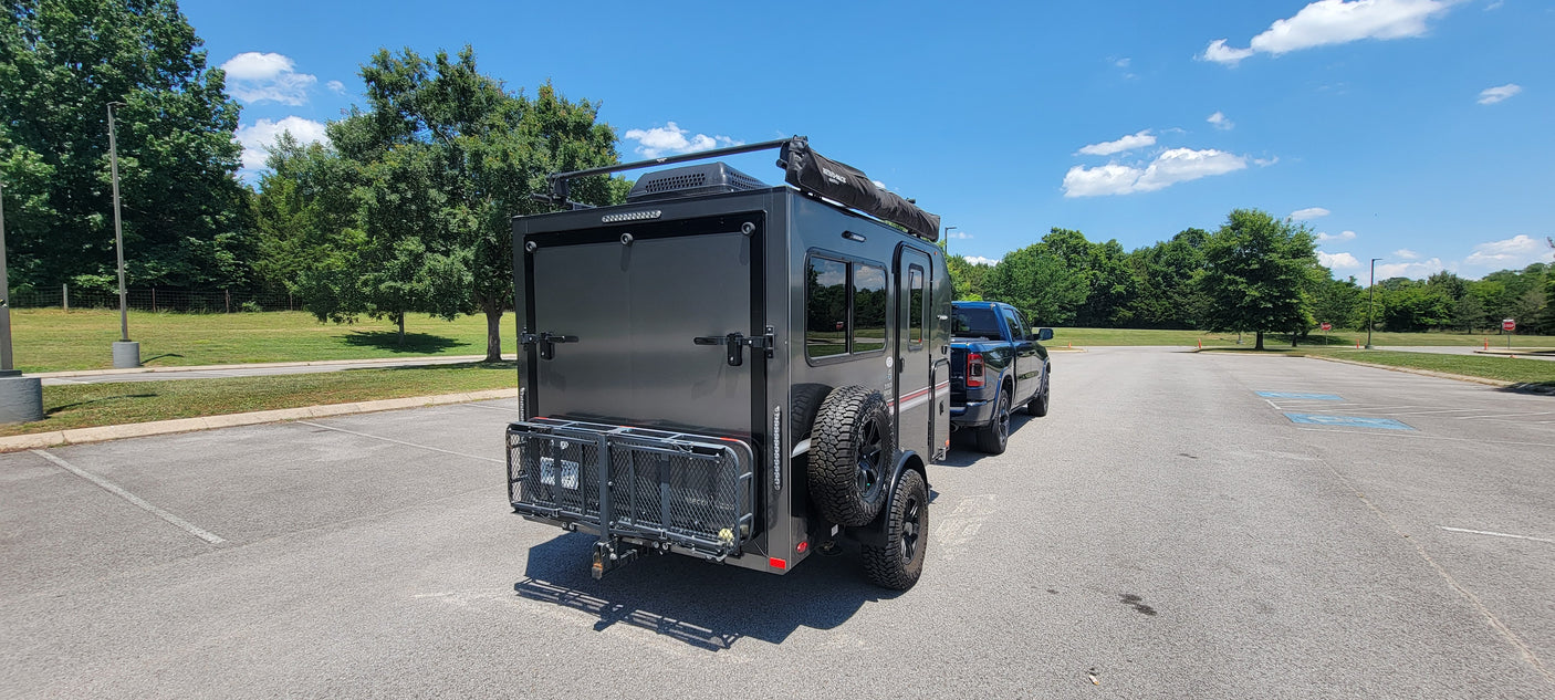 Off-road ready RV rental: A compact travel trailer hitched to a pickup, perfect for camping adventures.