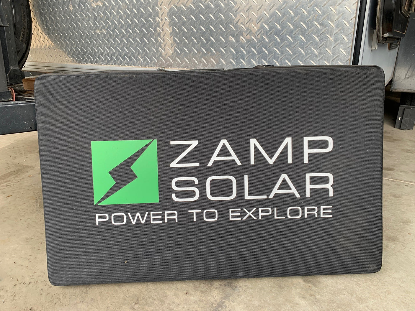 Black Zamp Solar case, with "Power to Explore" logo. Ideal portable solar power for RV rental adventures.