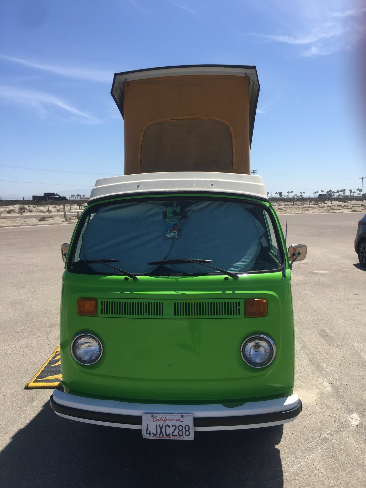 Bright green VW bus pop-top camper, perfect for an RV rental. Ready for sunny adventures!