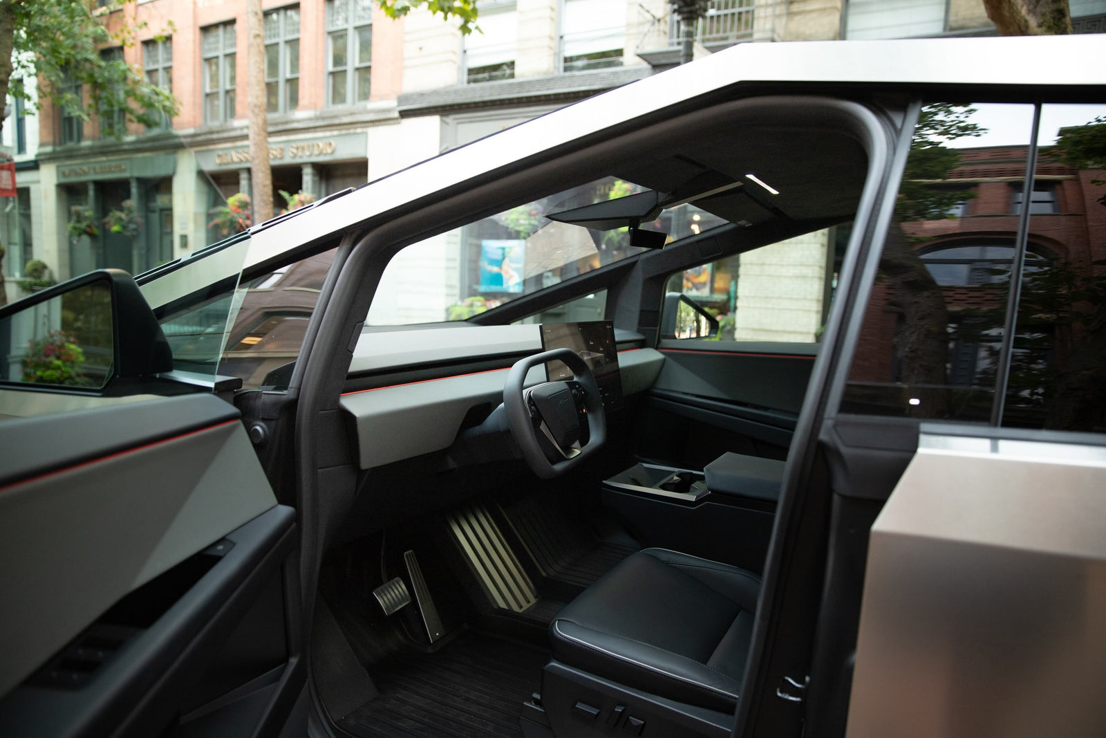Interior of a Tesla Cybertruck: a futuristic EV with a yoke steering wheel, minimalist dashboard, and sleek design. Not an rv rental.