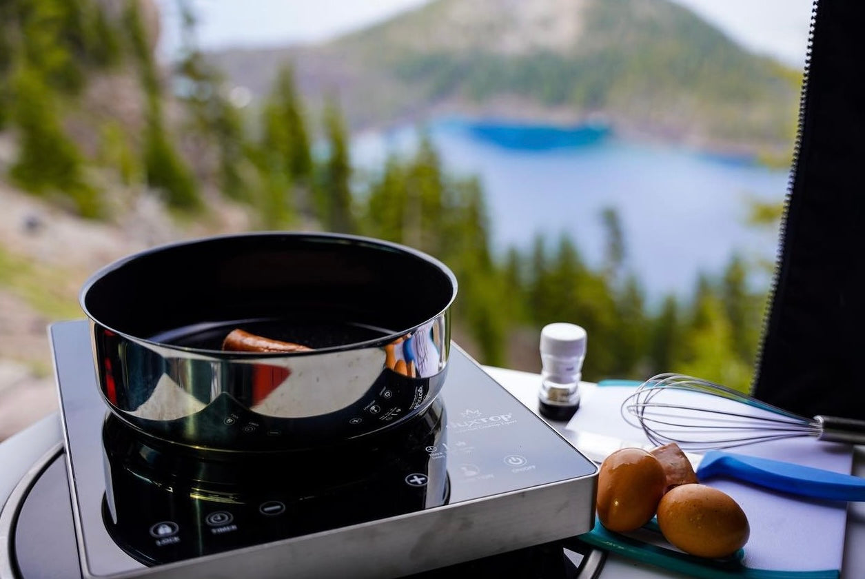 Cooking breakfast with a view from an RV rental: sausage, eggs, and whisk on an induction cooktop.