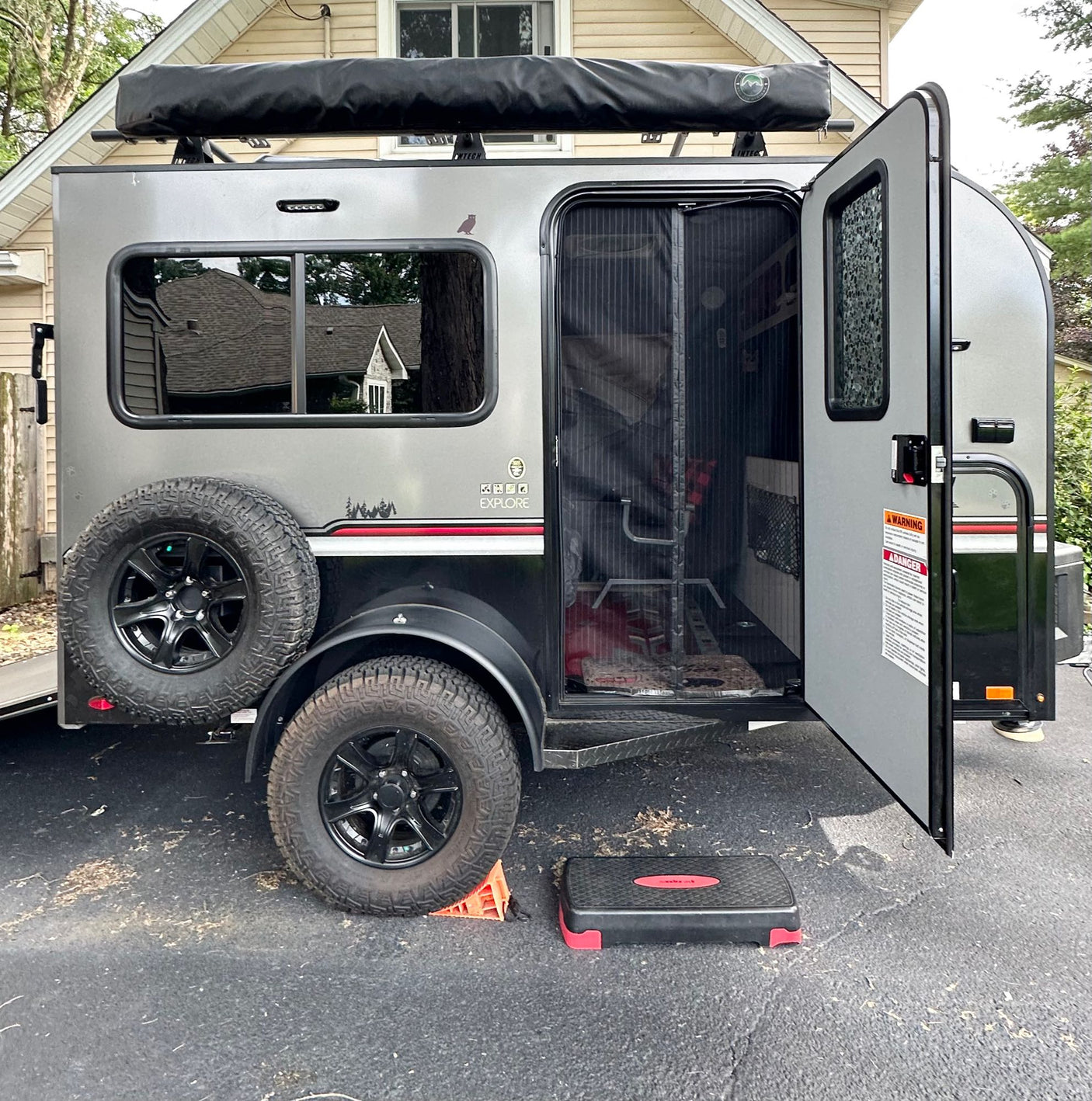 dark gray travel trailer/teardrop RV for rental. Features include an awning