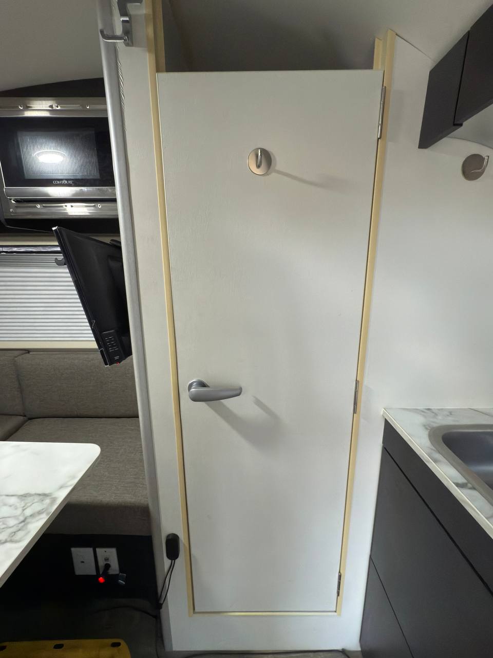 and soft blue lighting.|RV rental: U-shaped dinette area with a marble-patterned table
