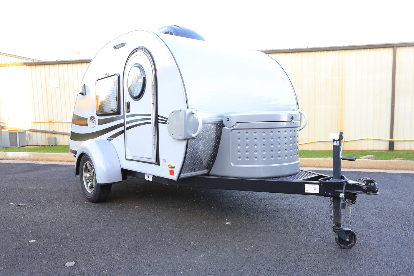 This compact grey teardrop travel trailer, available as an RV rental, is perfect for camping adventures.
