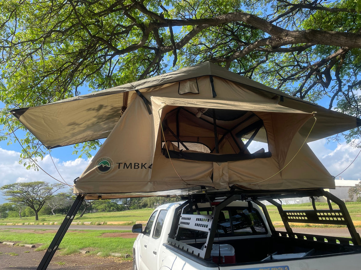 Explore with this RV rental: a white pickup truck equipped with a TMBK 4 rooftop tent for camping under large trees. — photo 8