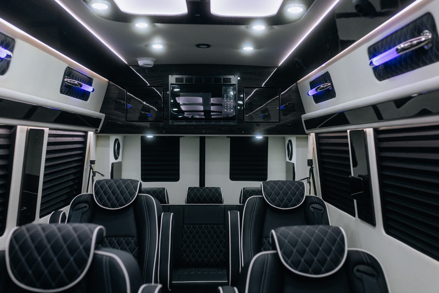 Experience luxury RV rental travel! Spacious custom van interior with quilted leather seating, microwave, and LED lighting.