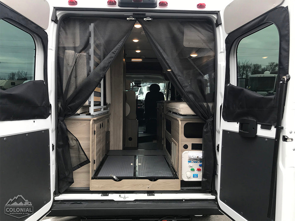 and passenger area. Perfect for adventures!|Versatile RV rental: Interior converts from dining table & bench to a full bed for comfortable sleep.|Cozy RV rental sleeping area: Colorful geometric comforter