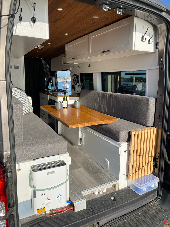 and stunning waterfront views out the back. Ideal for van life!|Gray RV rental van with an open side door
