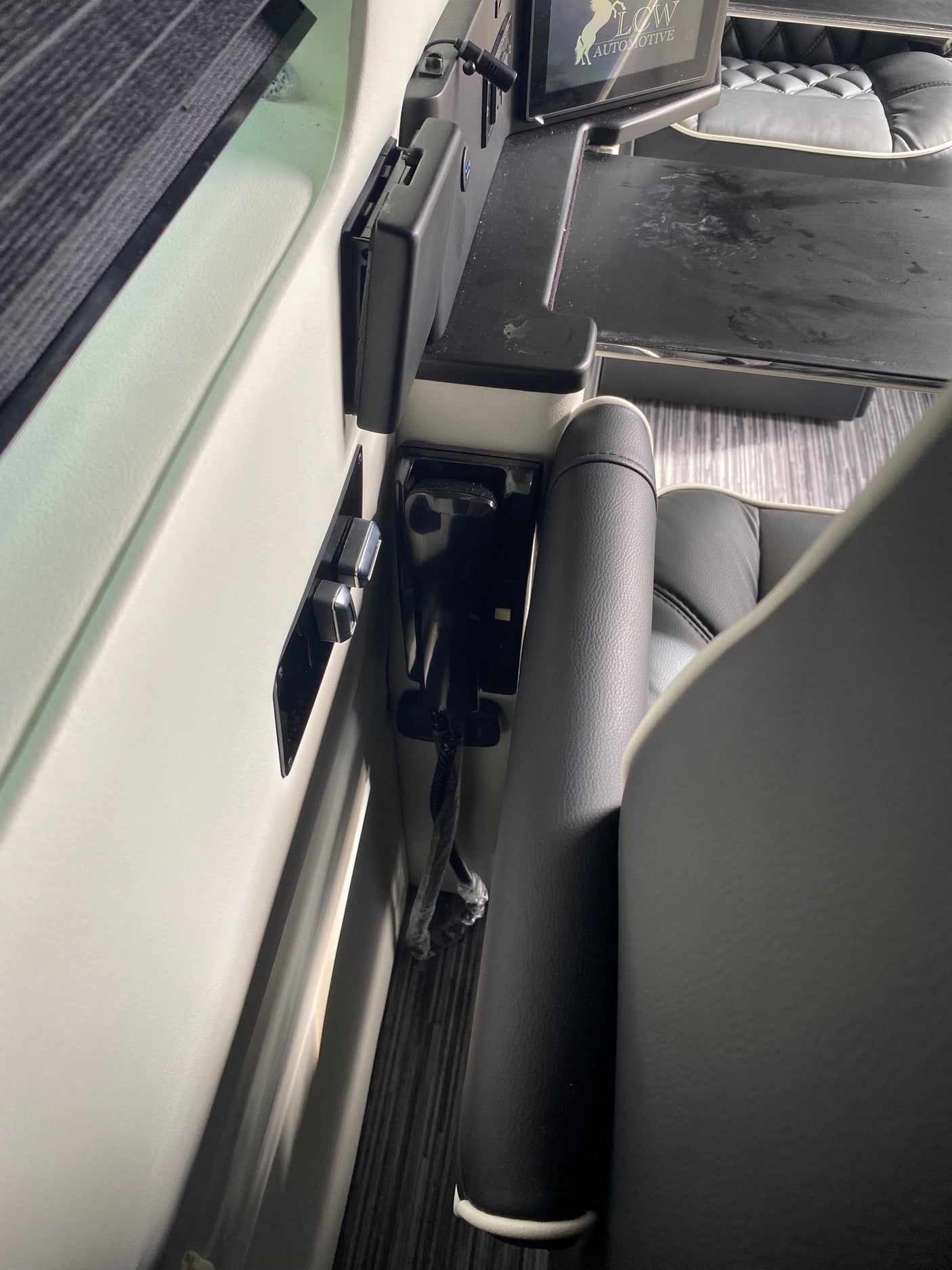 Luxury RV rental: detailed view of plush seating, integrated side control panel, and LOW AUTOMOTIVE display.