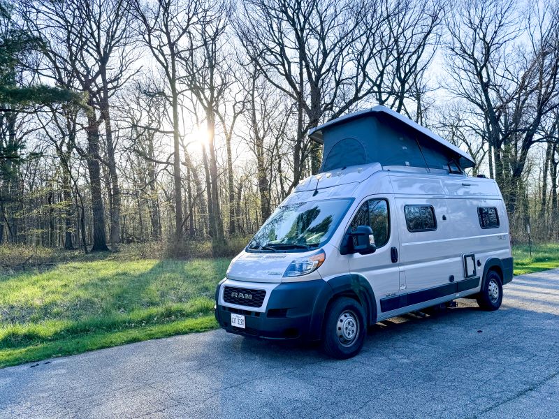 Light grey pop-top camper van for RV rental parked on an asphalt road