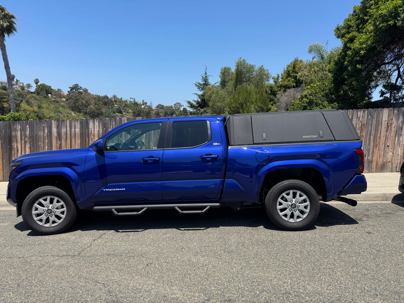 Blue Toyota Tacoma pickup with a SmartCap topper, perfect for camping adventures or an rv rental alternative.