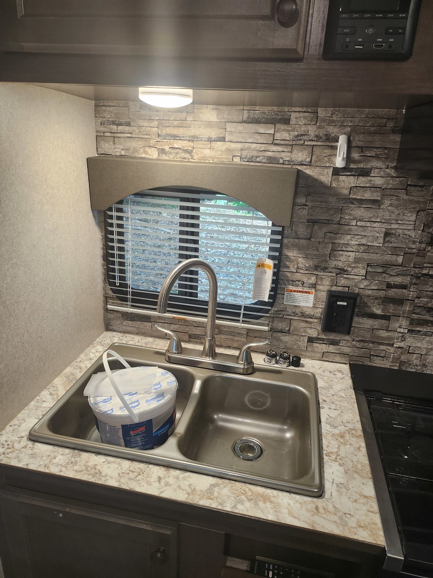 awning extended. Colorful homes in background.|RV rental kitchen: double sink
