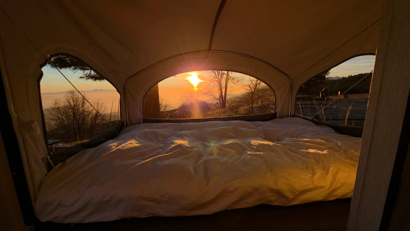 Cozy RV rental bed with stunning sunrise views! Perfect glamping adventure in nature.