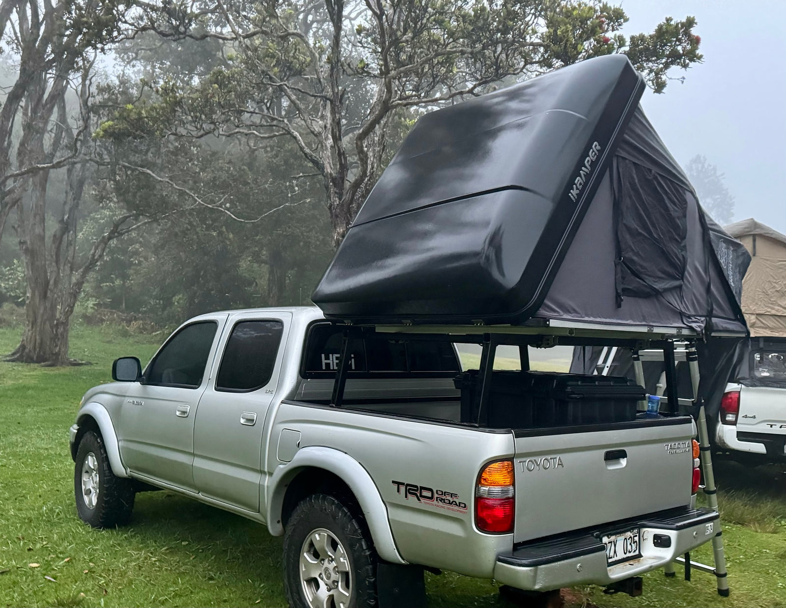 perfect for an overland RV rental trip in a misty forest.|Toyota Tacoma with iKamper rooftop tent ready for camping in misty woods
