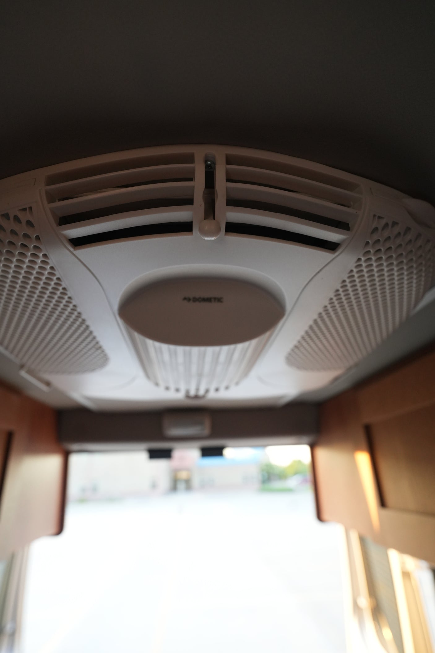 Close-up of a white Dometic air conditioning unit on an RV rental ceiling, showing adjustable vents for climate control.
