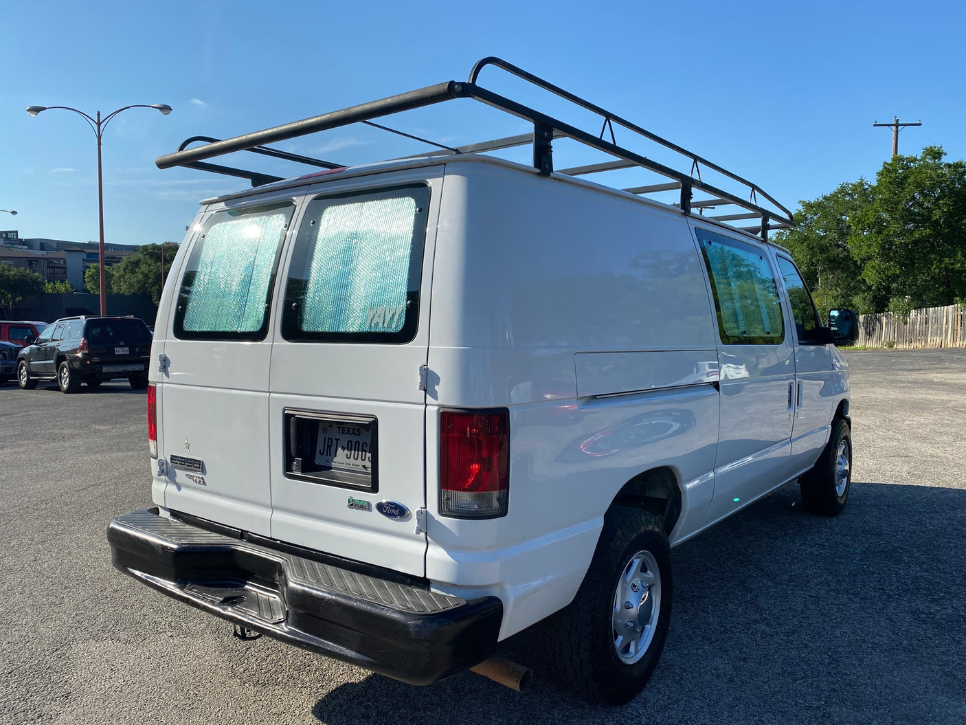 ready for mountain adventure. Scenic travel under blue sky.|Three friends cook at a sunny outdoor campsite with their RV rental vans