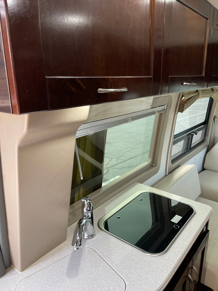 and rear sofa seating. Ideal for travel.|Inside a luxurious RV rental: sleek white seating