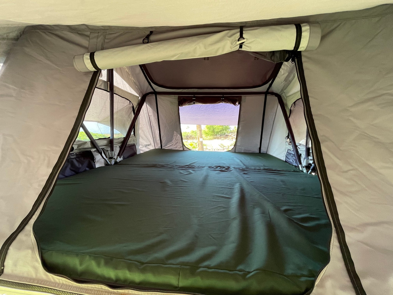 Spacious RV rental tent interior with a large green mattress and views, ideal for comfortable outdoor adventures.