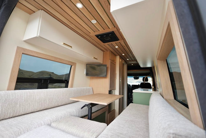 showing a modern interior with a green kitchen unit.|Inside a bright **rv rental**: cozy dinette