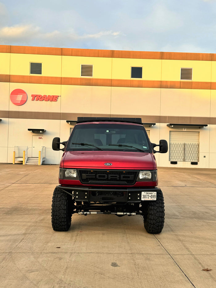 Custom red Ford adventure van, ideal for an rv rental, parked at a Trane facility in Texas.