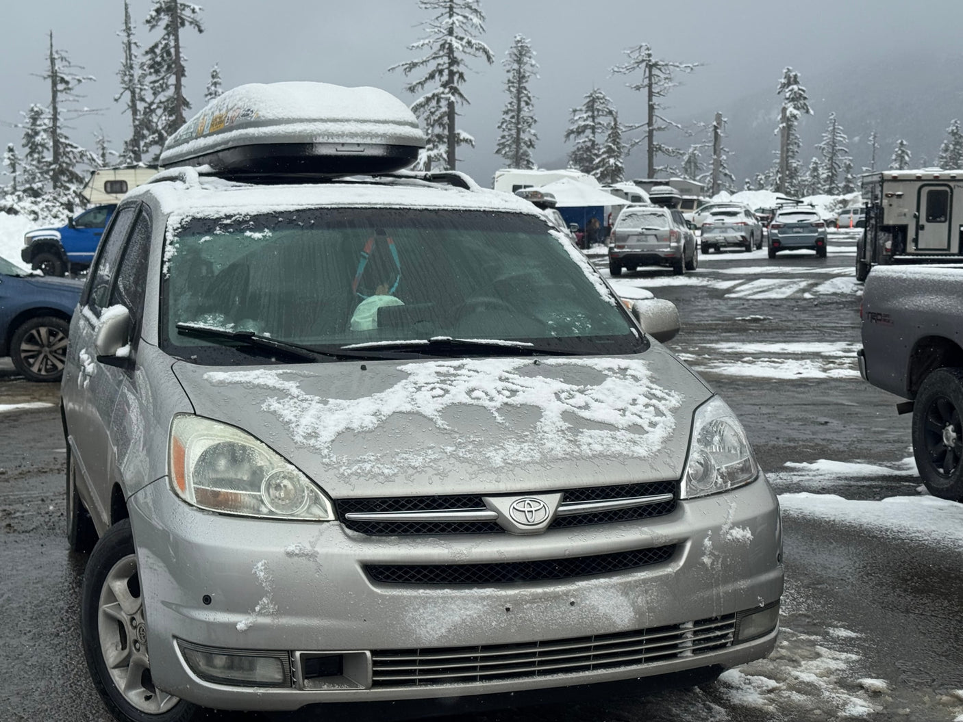 Silver minivan in a snowy lot