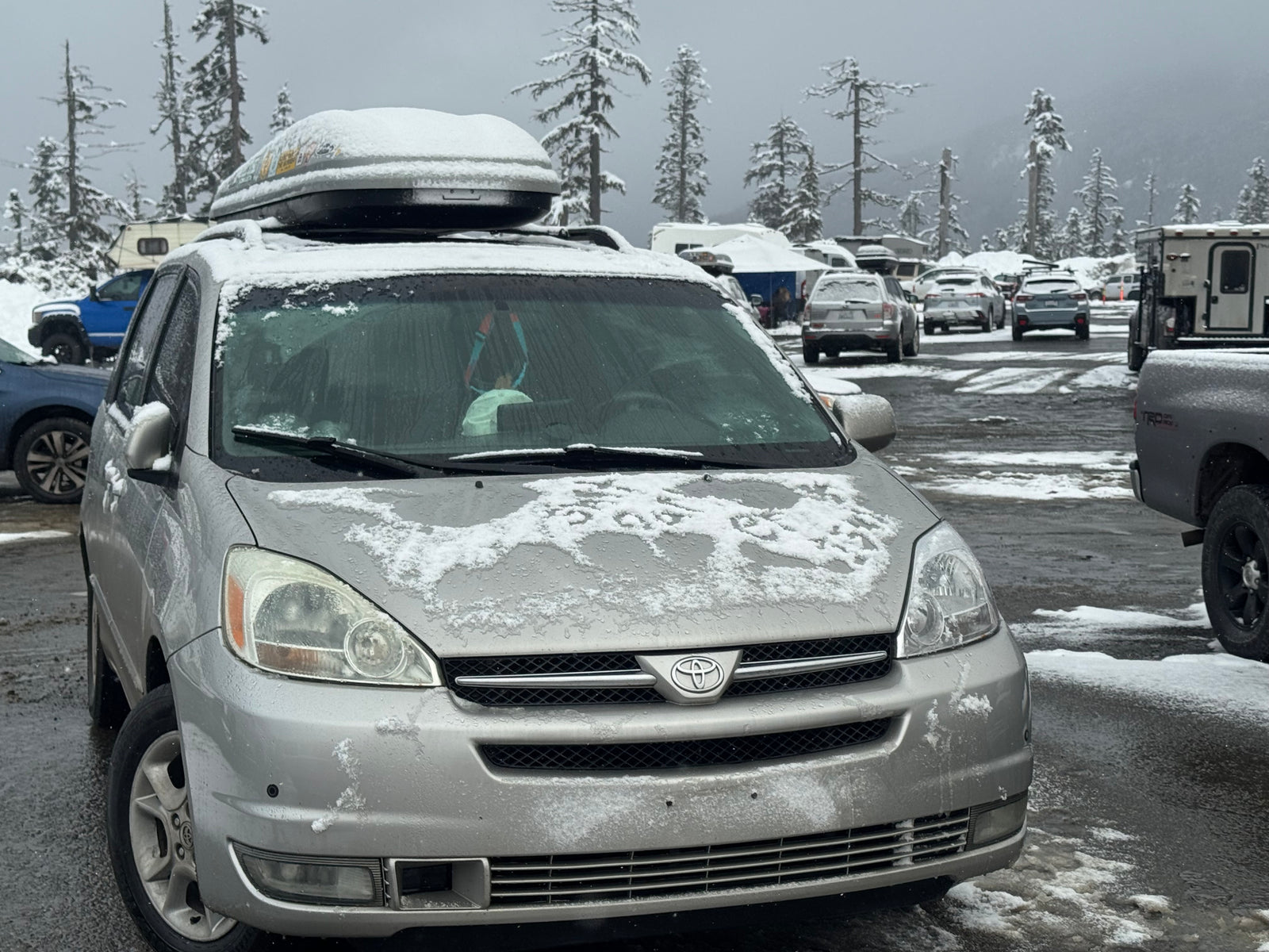Silver minivan in a snowy lot