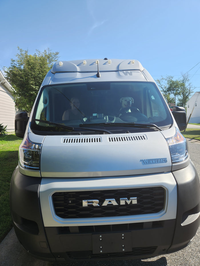 and blue sky with white clouds.|Silver camper van for RV rental