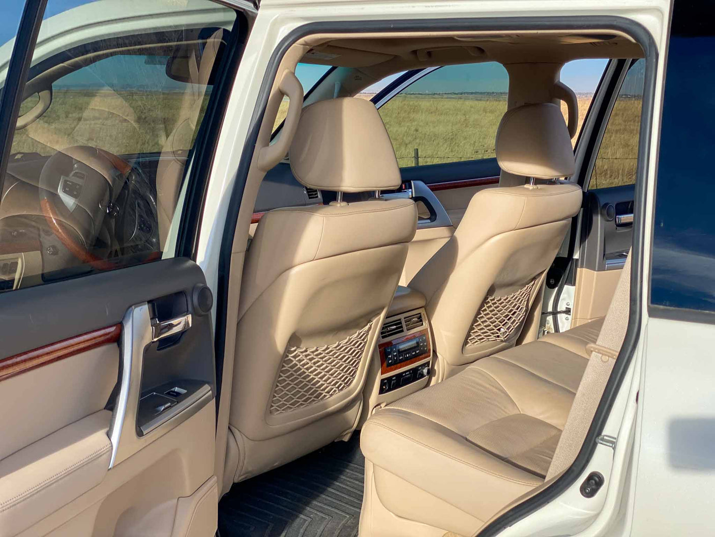 mountains in background.|Front view of a white Toyota Land Cruiser SUV