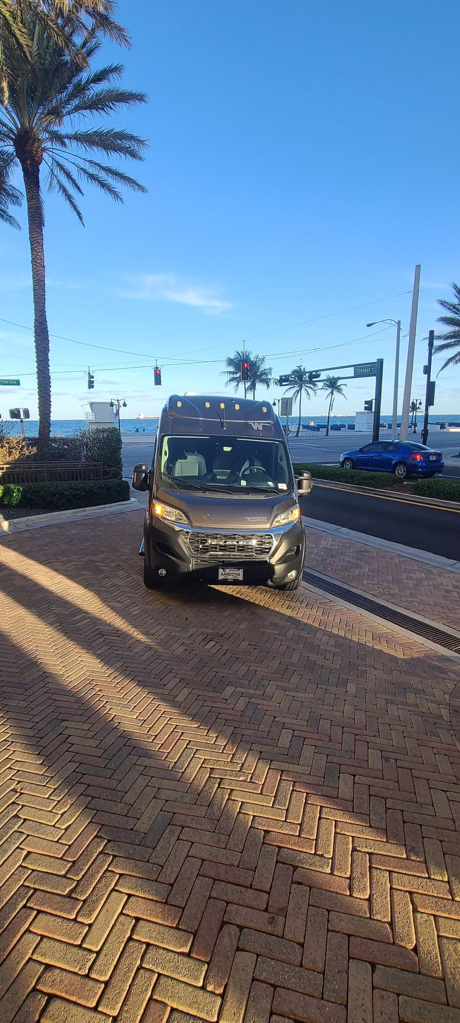 and a scenic beach road.|Dark grey Solis RV rental parked by ocean