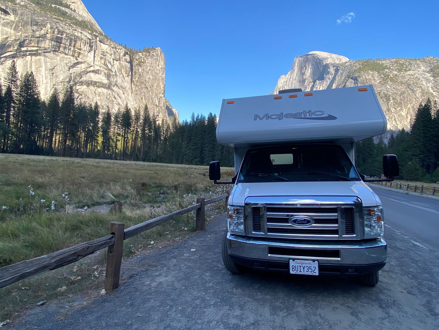 An RV rental parked in Yosemite Valley, showcasing towering rock formations & Half Dome. Ideal for a scenic nature trip.