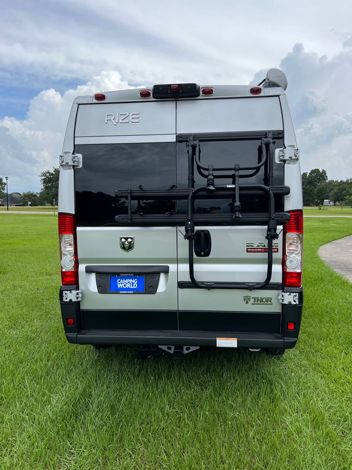 Rear view of a silver Thor Rize camper van, ideal for rv rental. Features include a Thule bike rack and Camping World license plate.